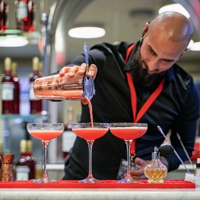 Bartender che prepara cocktail rosso con shaker, esempio di video amatoriale che non mette al centro il prodotto. Scopri il servizio di video ricette professionali di Drinkography.